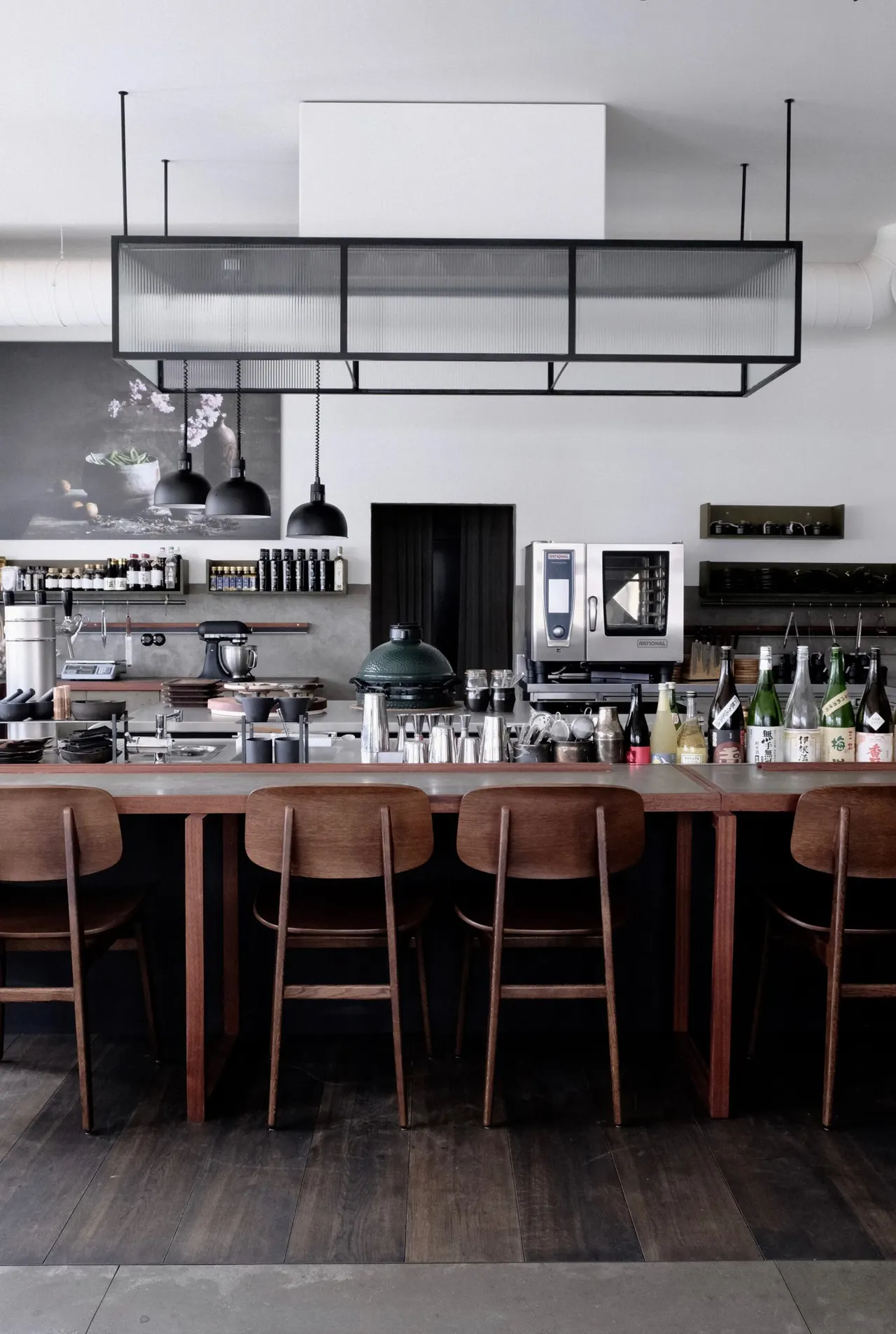 Bar met krukken en zwevend stalen rek in Atelier Paul Morel, Antwerpen