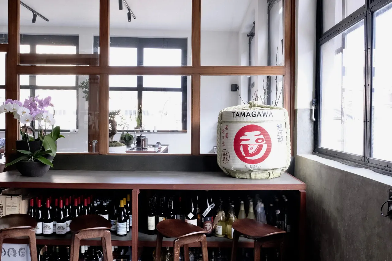 Houten kader met glas rond de bar en een sakevat