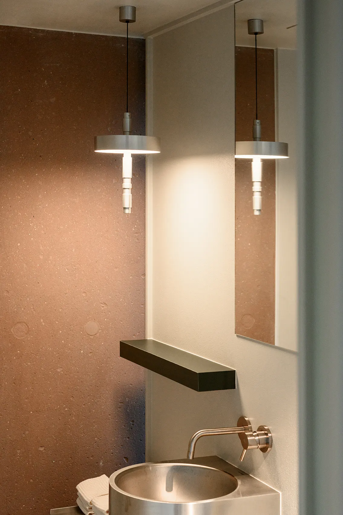Totm-hanglamp boven een inox wastafel in Bar Misera