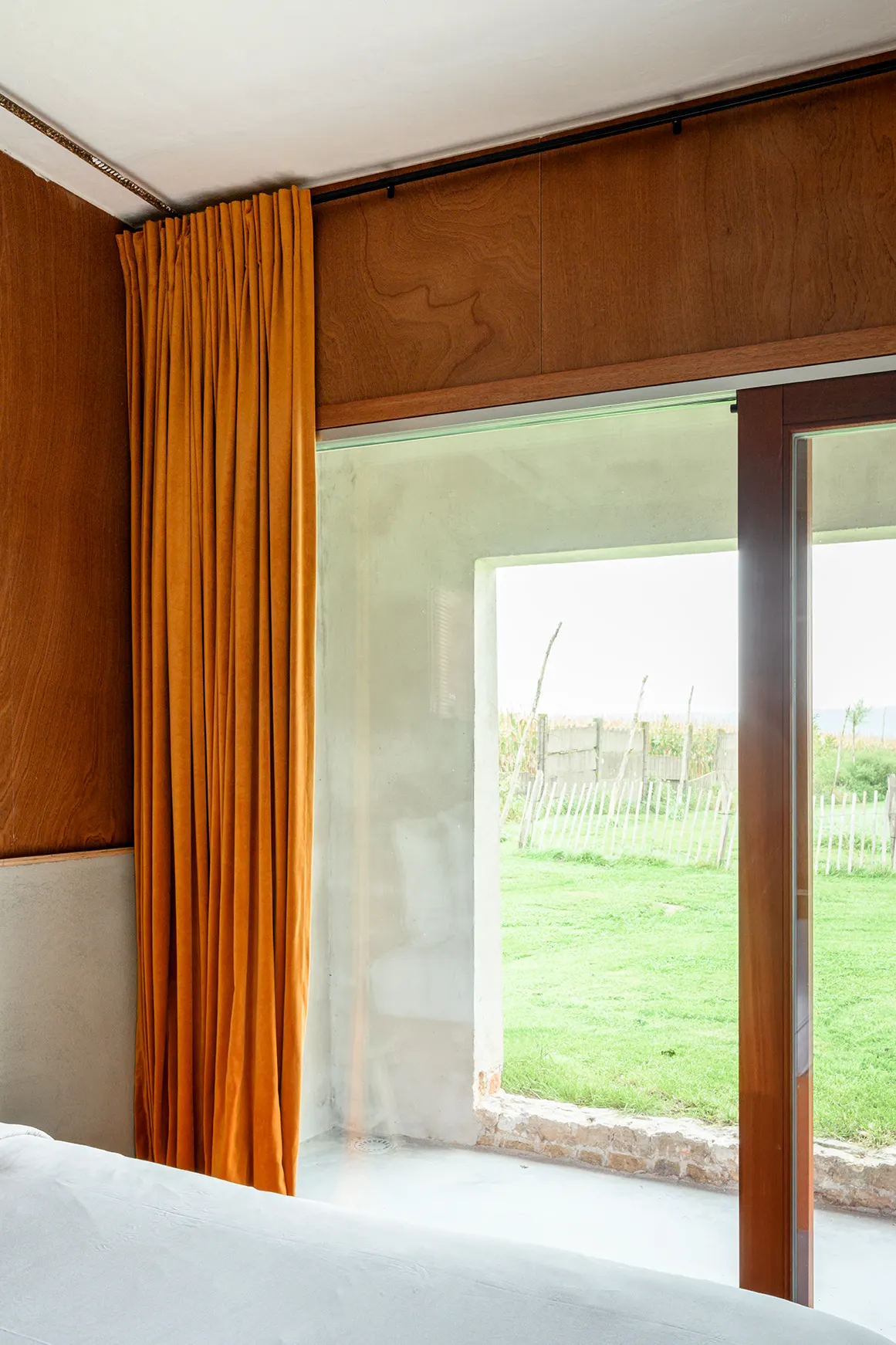 Kamer in B&B BBruT met okergeel gordijn en uitzicht op de polder