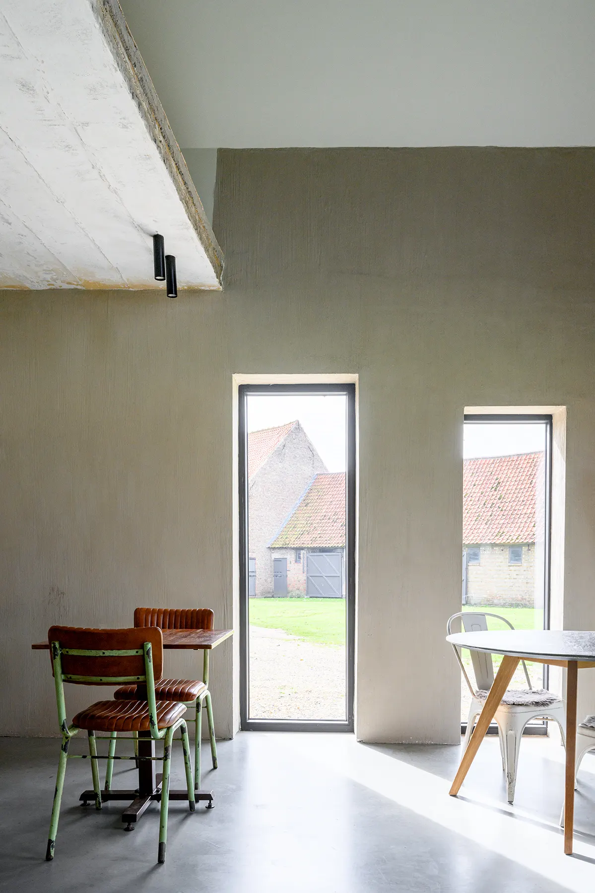 Ontbijtruimte met houten tafel en hoge glazen deur