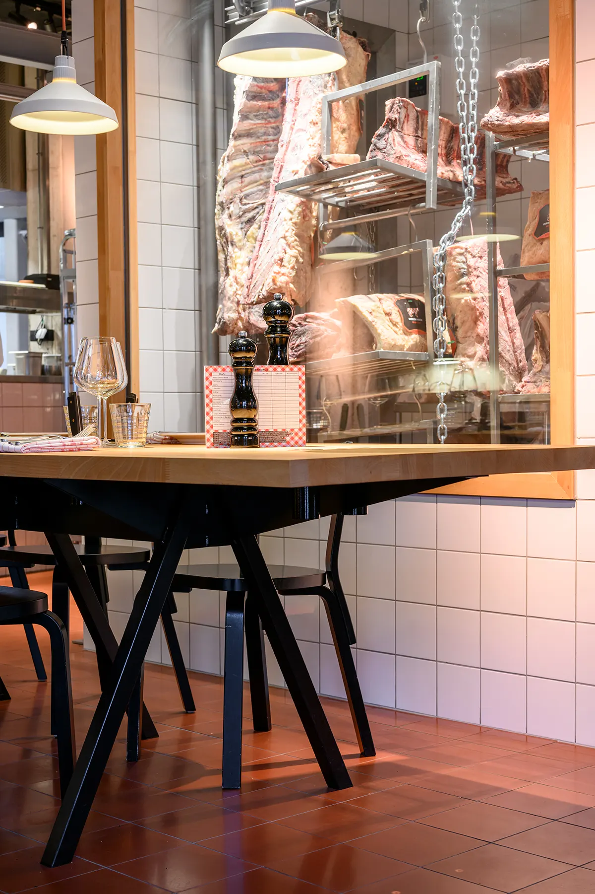 Rijpingskast met vlees boven een beuken tafel
