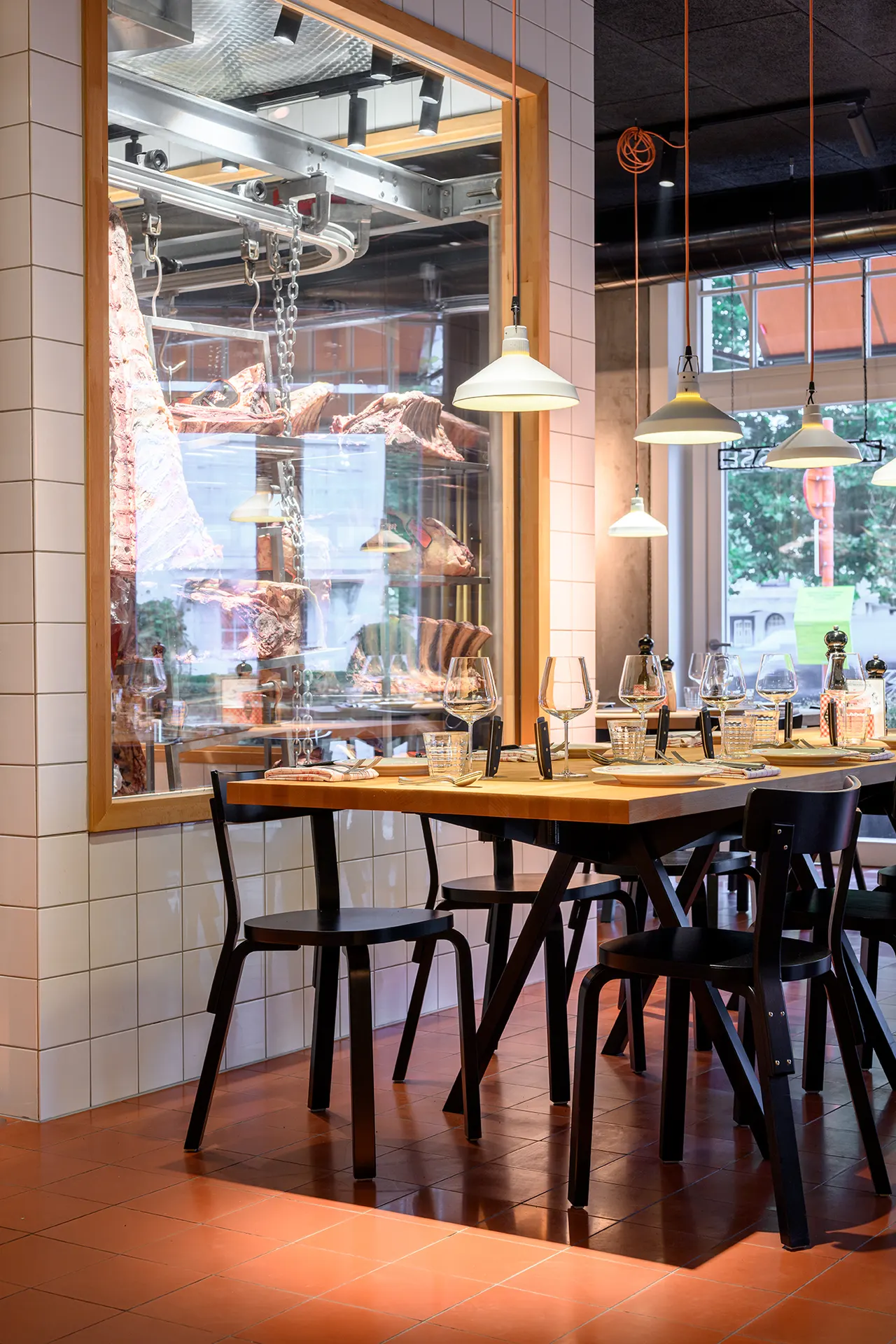 Tafel bij een raam met witte tegels en hanglampen