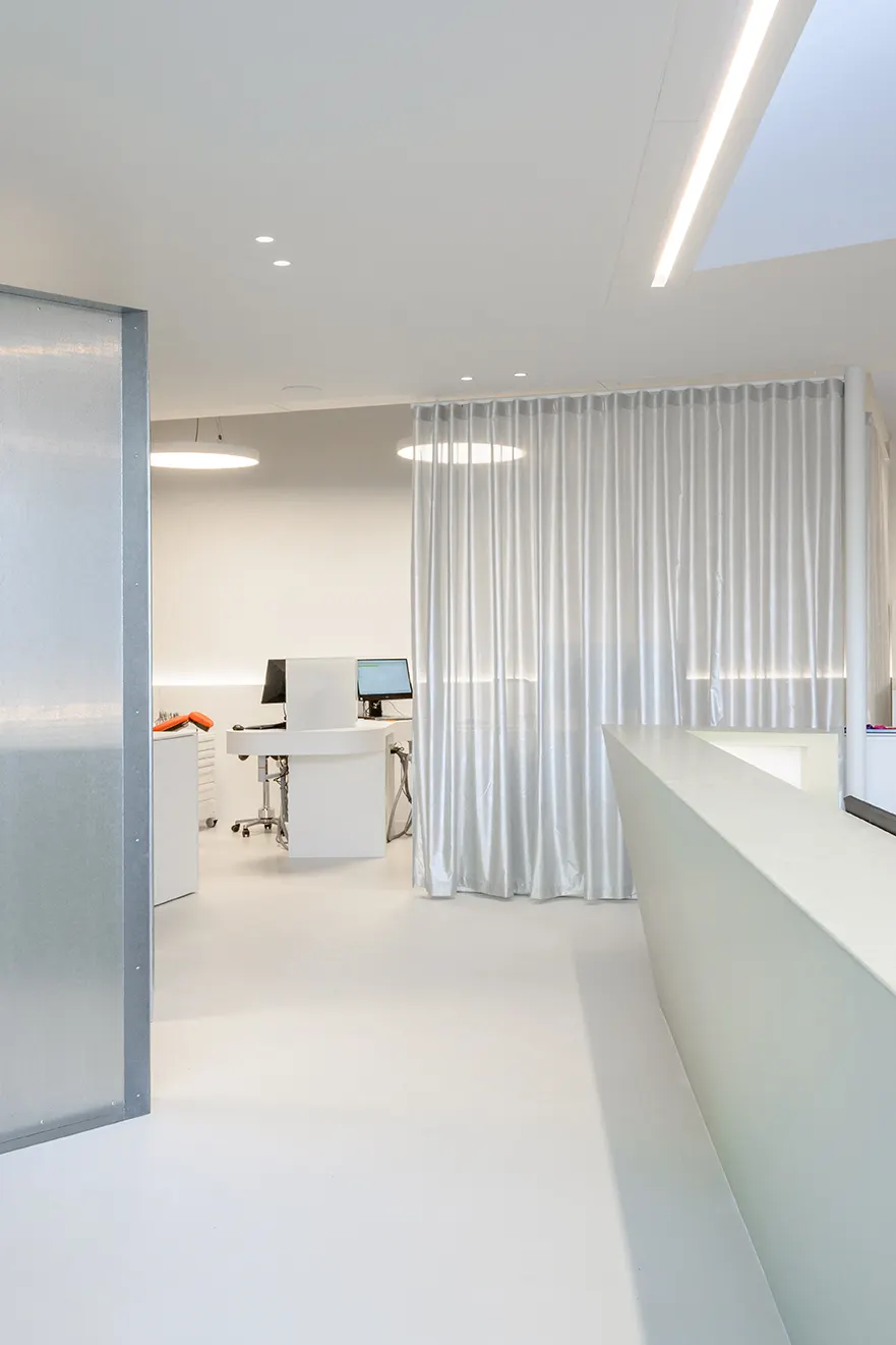 Witte balie en zilveren gordijnen in De Orthodontist in Veurne