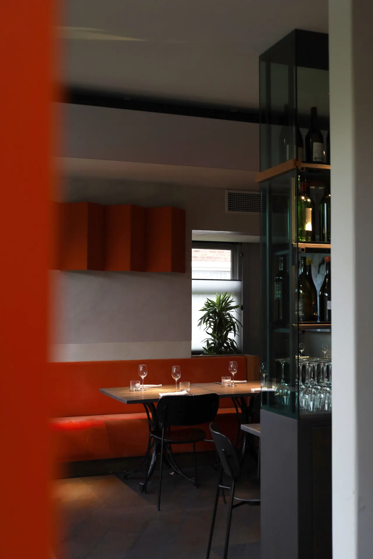 Rode bank en oranje wand in de zaal van Het Vliegend Tapijt
