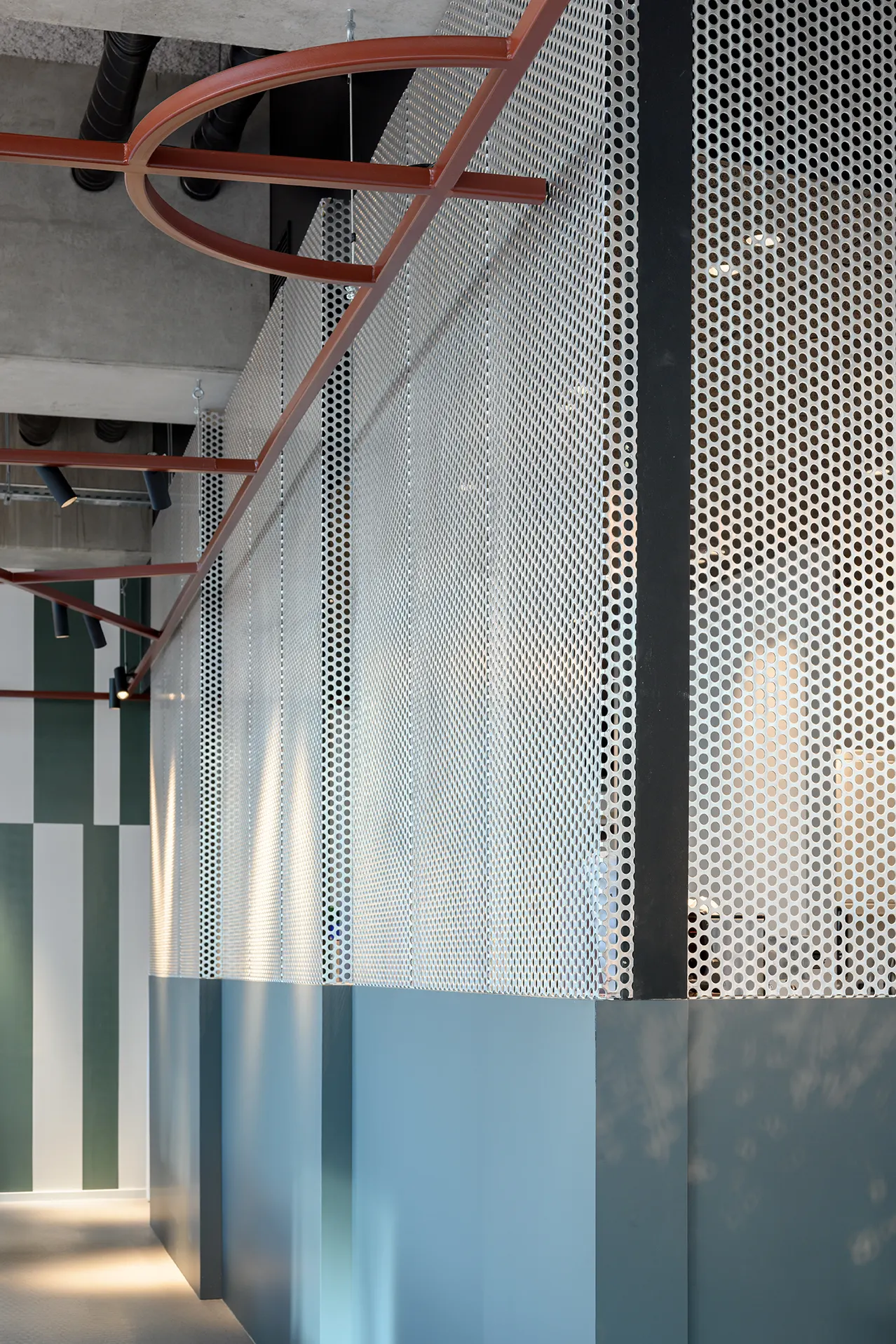 Geperforeerd metalen scherm en groene wand in de zaal