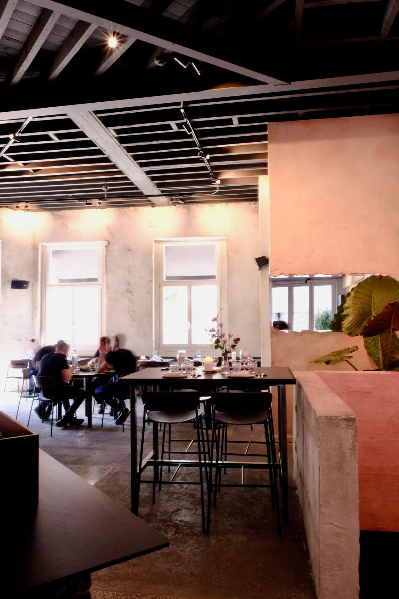 Donker plafond met rails boven de zaal en toog van Lewis