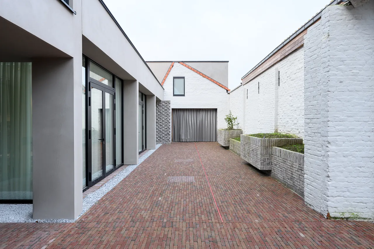 Binnenkoer met rode klinkers langs de witte gevels van M-Bistro