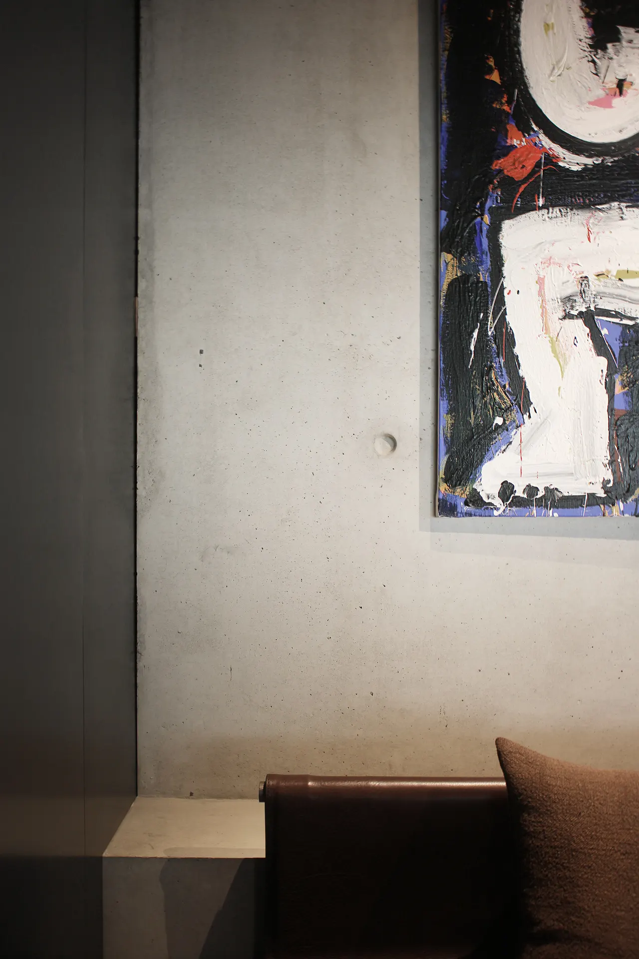 Kunstwerk boven een bank in de donkere zaal van Misera