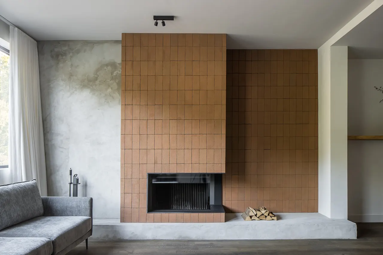 Woonkamer met haard in terracotta tegels bij Nick Bril in Antwerpen