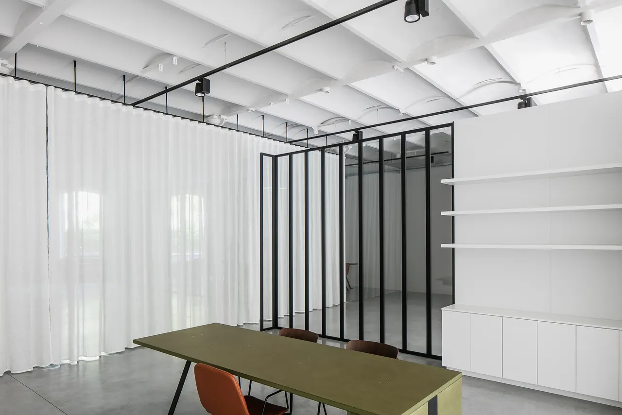 Zwarte glaswand en tafel tussen witte voiles