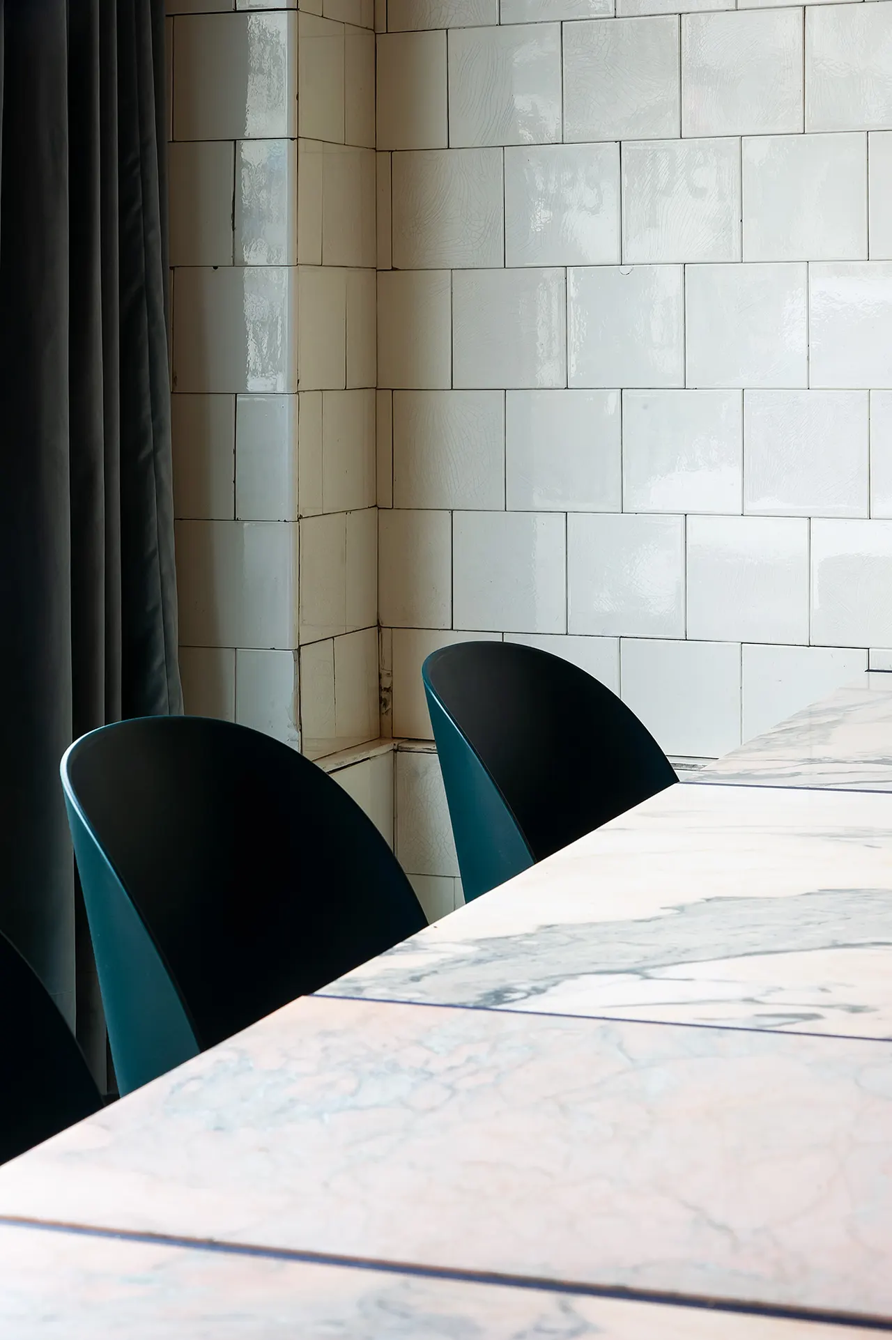 Bar in roze natuursteen met blauwe stoelen in restaurant Souvenir in Gent