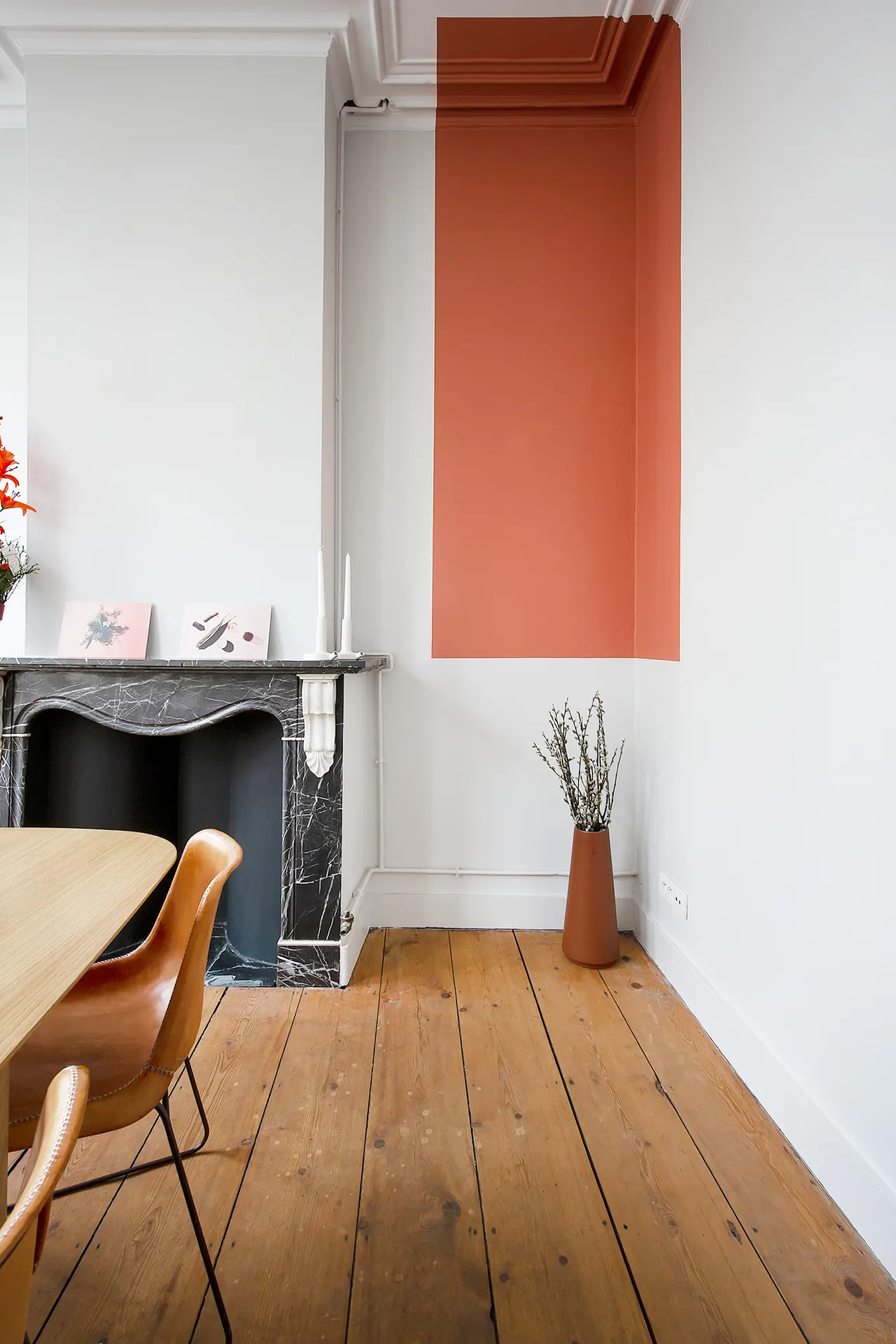Oude schouwmantel en terracotta kleurvlak op een houten vloer