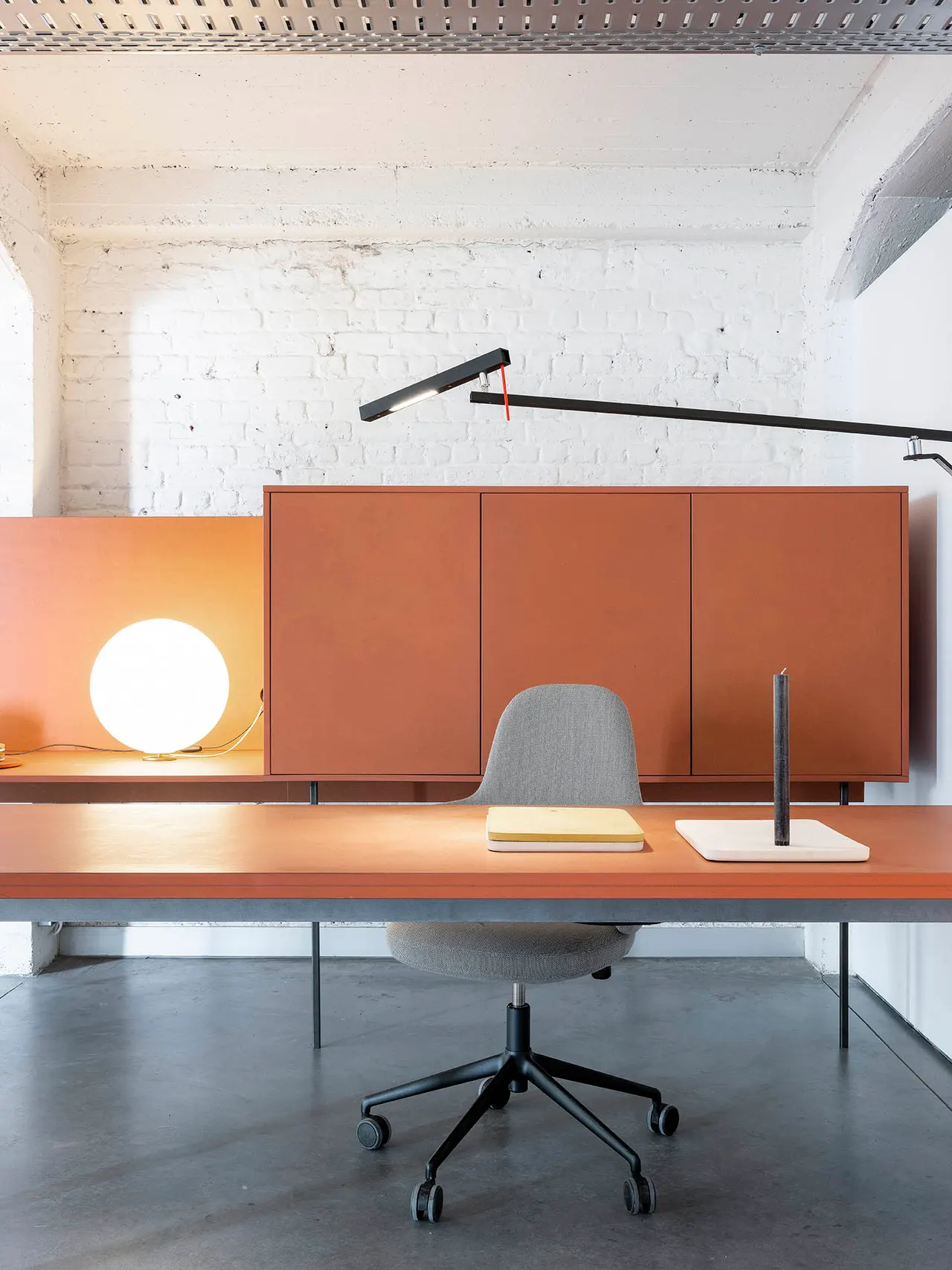 Werkplek met bureaulamp en terracotta kast