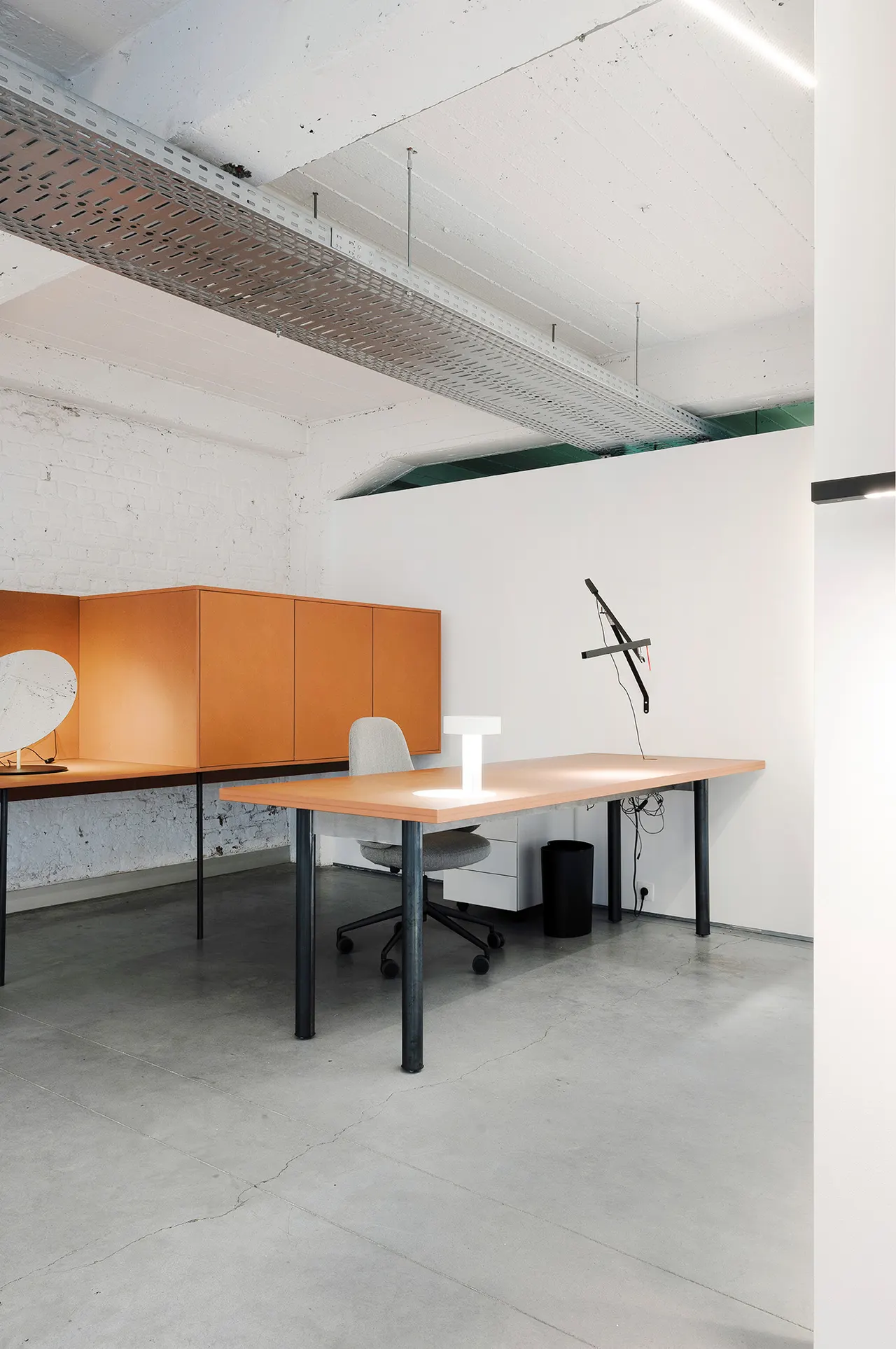 Werkplek met lamp tegen een witte bakstenen muur