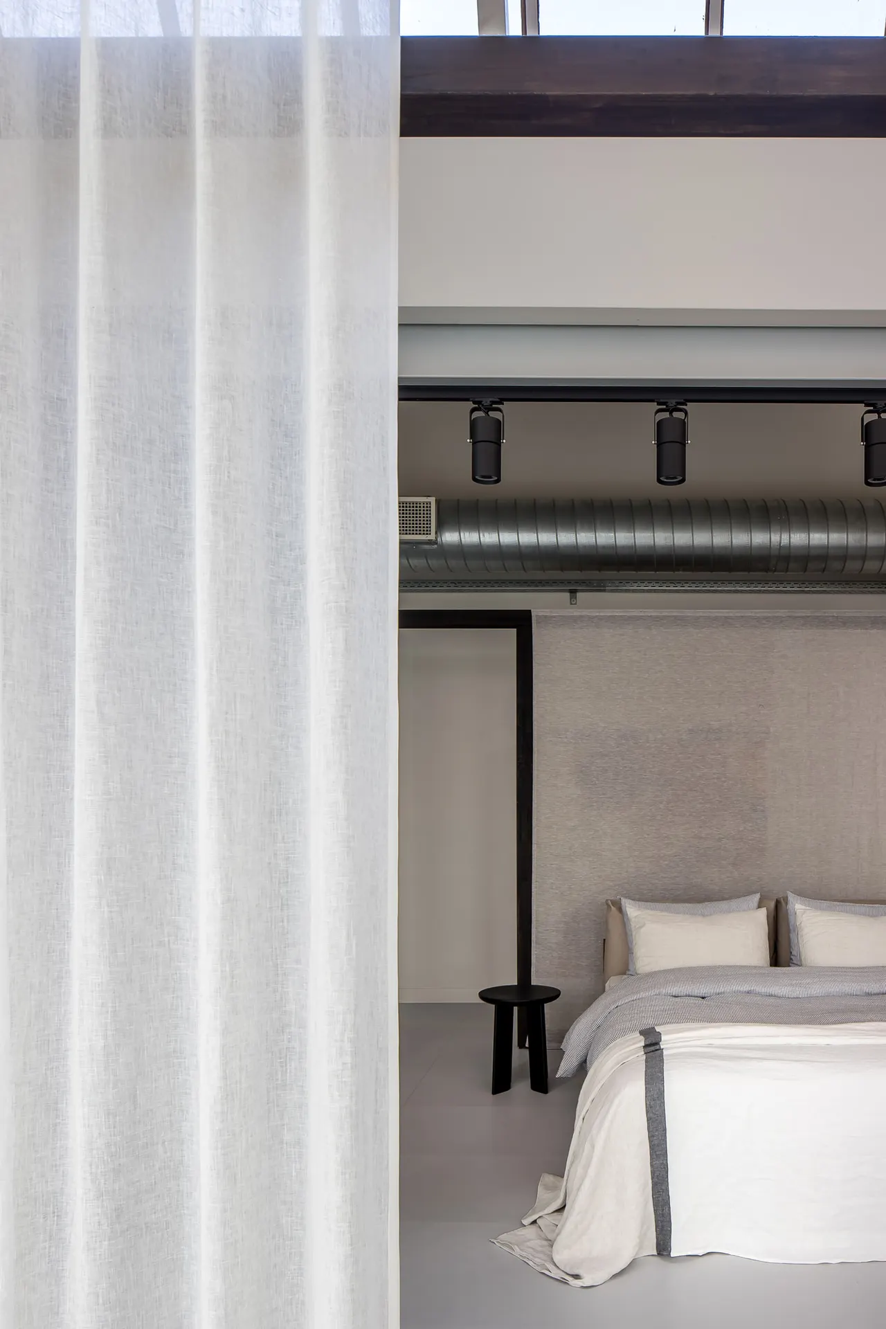 Bed met linnen beddengoed achter een voile