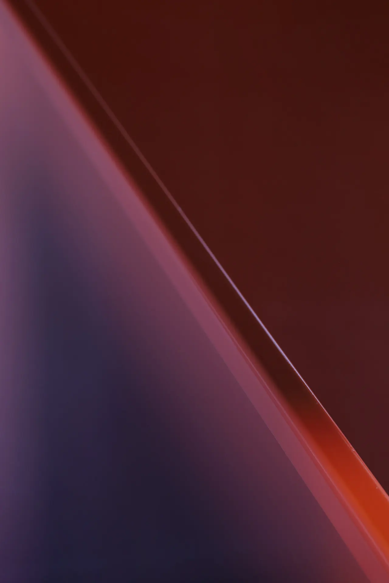 Detail van een rode gelakte wand in strijklicht