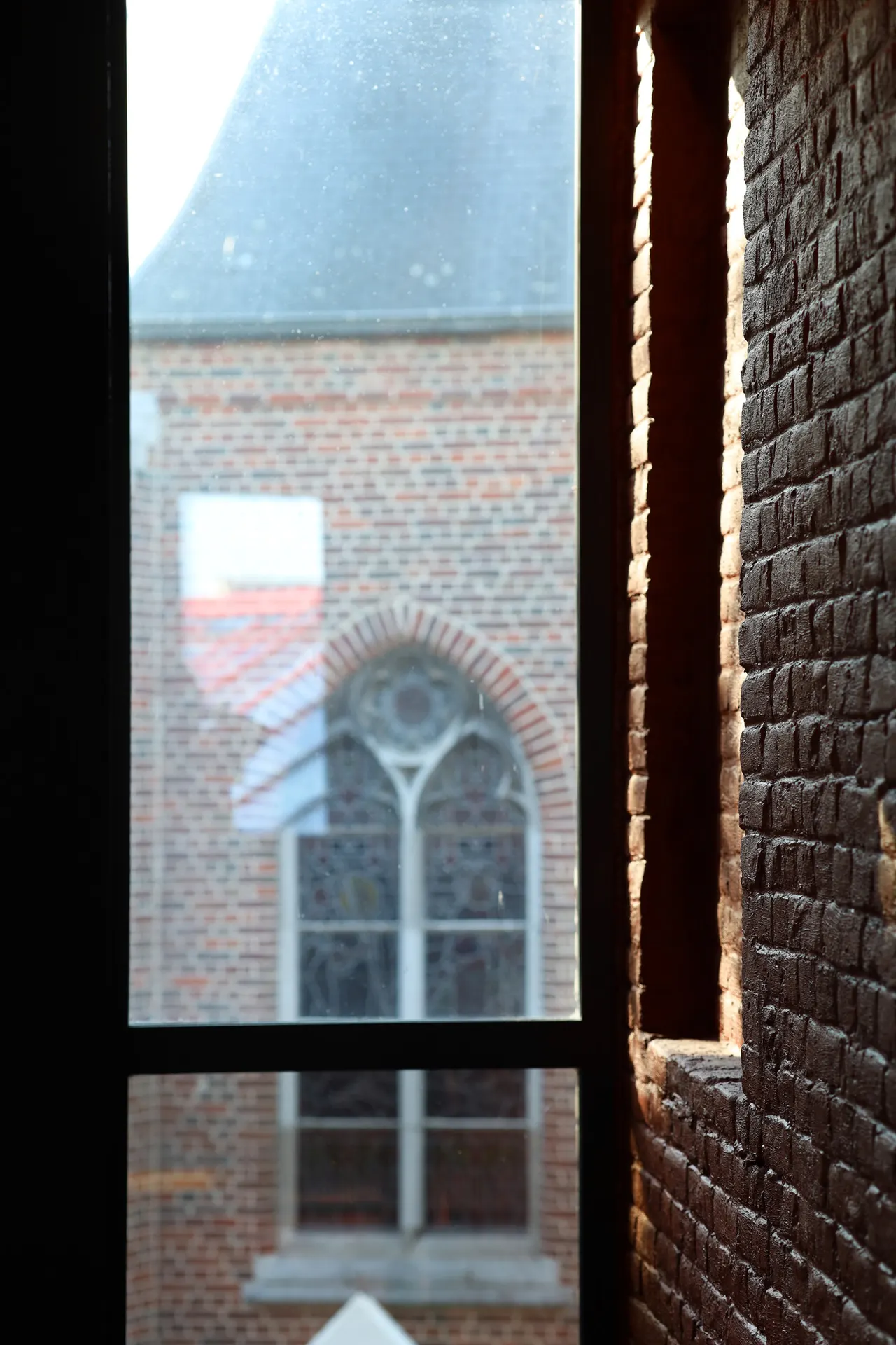 Zicht door het raam op de kerk van Kachtem