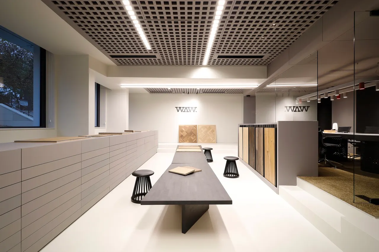 Showroom van WAW Floors in Parijs met lange presentatietafel en ladewand